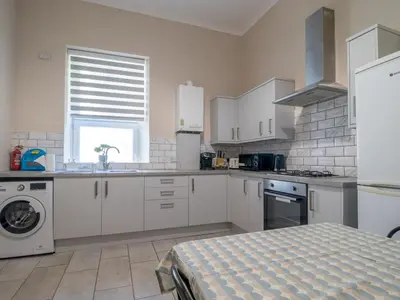 a large kitchen with white cabinets and a window at City Haven Main Door & Parking - Pass the Keys in Glasgow