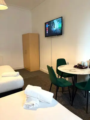 a hotel room with a table and a tv on the wall at Piccolo in Glasgow
