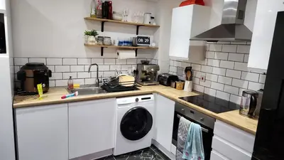 a kitchen with a washing machine and a sink at Modern Room in a Shared Flat near Haymarket in Edinburgh