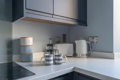 a kitchen counter with cups and appliances on it at Prime Stay Apartments in Paisley