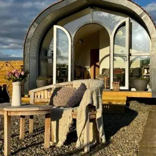 a couch sitting in front of a round house at Heather Pod in Perth