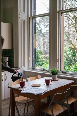 a wooden table in a room with a window at 7 Crown Gardens Glasgow in Glasgow