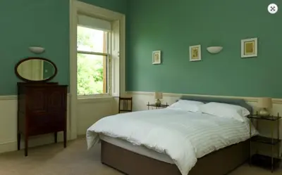 a bedroom with a bed and a mirror and a window at 7 Crown Gardens Glasgow in Glasgow