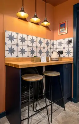 a kitchen with a counter and two stools at a bar at The Unique Cathedral Hideaway in Stirling