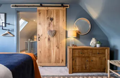 a bedroom with a wooden door and a mirror at The Unique Cathedral Hideaway in Stirling