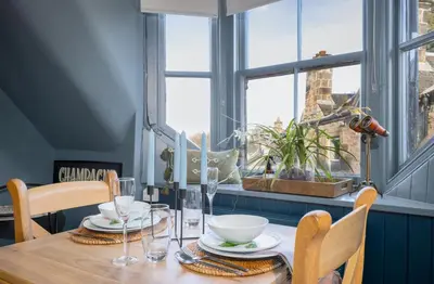 a wooden table with plates and bowls on top of it at The Unique Cathedral Hideaway in Stirling