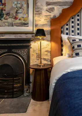 a bedroom with a fireplace and a bed and a lamp at The Unique Cathedral Hideaway in Stirling