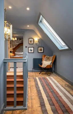 a attic room with a skylight and a chair at The Unique Cathedral Hideaway in Stirling