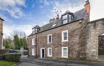 an old brick building with white windows on a street at The Unique Cathedral Hideaway in Stirling