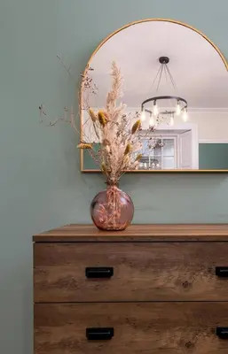 a vase on top of a dresser with a mirror at Charming and Cosy Getaway in Cambusbarron