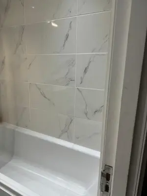 a bathroom with a shower with white marble walls at The City Glasgow in Glasgow