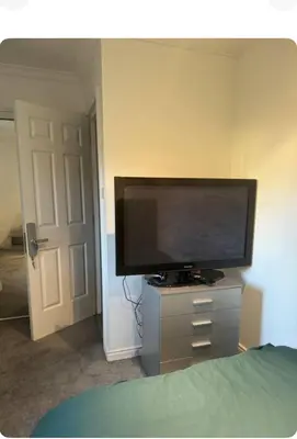 a flat screen tv sitting on a dresser in a bedroom at The City Glasgow in Glasgow