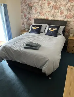 a bedroom with a large bed with blue pillows at The Bee Hive Hotel in Coylton