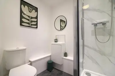 a white bathroom with a shower and a toilet at Signature - St James House in Abbotsinch