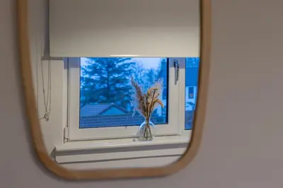 a mirror reflecting a window with a plant in a vase at Boswell House - Modern 3 Bed House East Kilbride Close to Motorway in East Kilbride