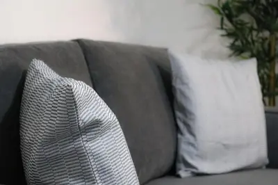 a gray couch with two pillows on it at Sonas Apartment in Greenock