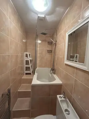a bathroom with a tub and a toilet and a sink at The Bay View Apartment in Gourock