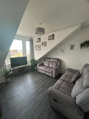 a living room with a couch and a tv at The Bay View Apartment in Gourock