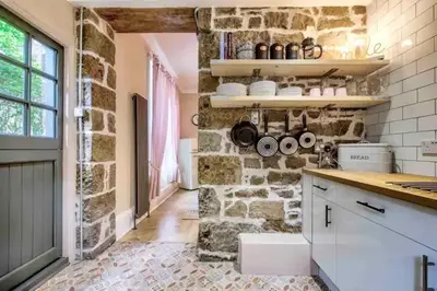 a kitchen with a stone wall and a counter top at Maya's Holiday Homes in Glasgow