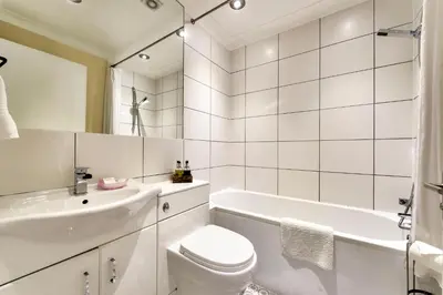 a white bathroom with a tub and a toilet and a sink at Maya's Holiday Homes in Glasgow