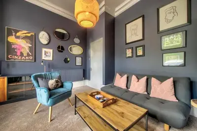 a living room with a couch and a table and a chair at Maya's Holiday Homes in Glasgow