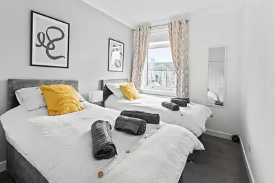a bedroom with two beds and a window at Grangeburn Residence - 2 bedroom home with parking in Falkirk