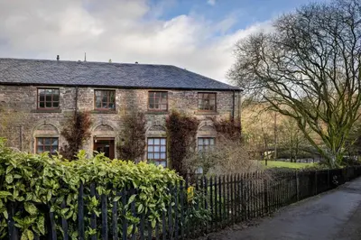 an old brick house with a fence in front of it at The Mill Retreat in Stirling