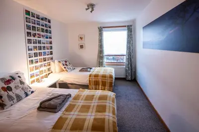 a bedroom with two beds and a window at 12 & 14 On the Hill Aberfoyle, twin holiday cottages in Scenic Loch Lomond & Trossachs National Park in Aberfoyle