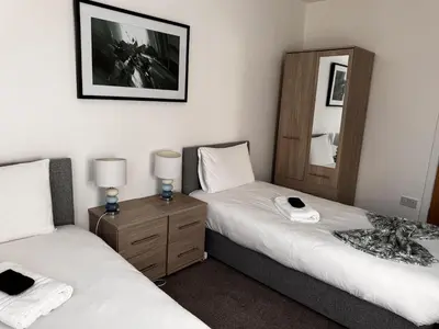 two beds in a room with two lamps and a mirror at Loch Ore View in Kelty
