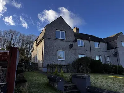 a large brick house with a fence in front of it at Loch Ore View in Kelty