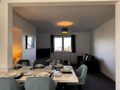 a dining room with a long table and chairs at Loch Ore View in Kelty