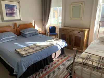 a bedroom with two beds and a dresser and a window at Foresters 4 Bedroom Apartment in Cambusbarron