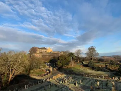 a view of a cemetery with a castle in the background at Foresters 4 Bedroom Apartment in Cambusbarron