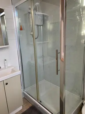a shower with a glass door in a bathroom at Foresters 4 Bedroom Apartment in Cambusbarron