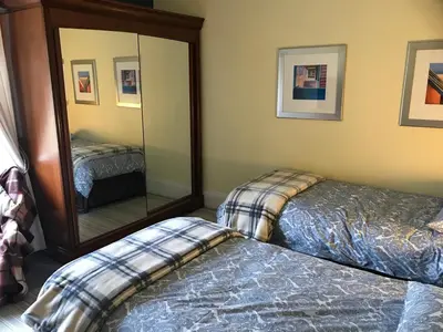 a bedroom with two beds and a mirror at Foresters 4 Bedroom Apartment in Cambusbarron