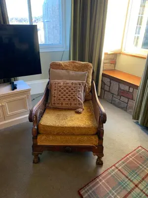 a chair with a pillow on it in a living room at Foresters 4 Bedroom Apartment in Cambusbarron