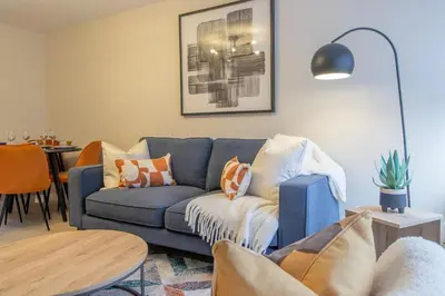 a living room with a blue couch and a table at Hawick Apartment- 2-Bed in Coatbridge, Mins from Motorway to Glasgow in Old Monkland