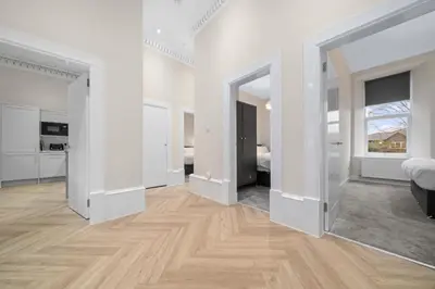 an empty room with white walls and wooden floors at Paisley Road Courtyard in Glasgow