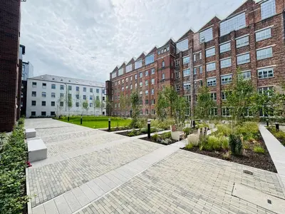 a courtyard in front of a large brick building at Modern Flat in Glasgow City FREE Parking & Wifi in Glasgow