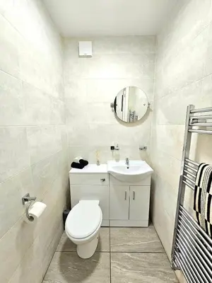 a bathroom with a toilet and a sink and a mirror at Warm & Cosy Home in Glasgow in Glasgow