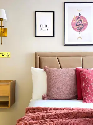 a bedroom with a bed with pink and white pillows at Warm & Cosy Home in Glasgow in Glasgow