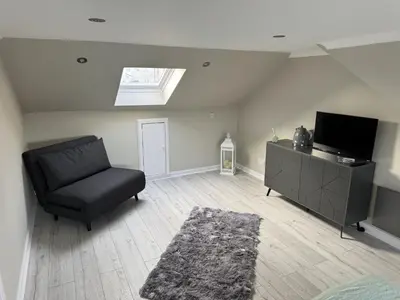 a living room with a chair and a flat screen tv at Caplawhead in Armadale