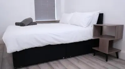 a large bed with a night stand next to it at Newly refurbished 2 bed ! in Glasgow