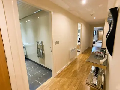 a living room with a large glass door leading to a kitchen at Glasgow 2bd near Hydro SECC City Centre Great Location in Glasgow