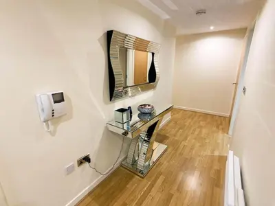 a bathroom with a mirror and a wooden floor at Glasgow 2bd near Hydro SECC City Centre Great Location in Glasgow