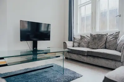 a living room with a couch and a tv at 2 bed Renfield st City Center in Glasgow