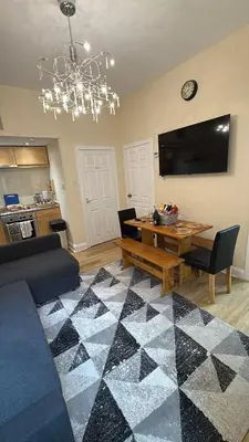 a living room with a table and a chandelier at Flat in Central Edinburgh Old town in Edinburgh