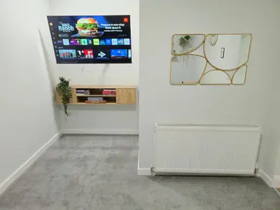 a living room with a radiator and a tv on a wall at 3-Bed Home in Glasgow in Glasgow