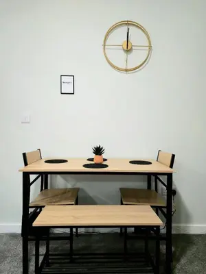 a table with benches and a clock on the wall at 3-Bed Home in Glasgow in Glasgow