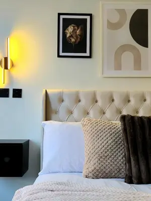 a bedroom with a bed with a headboard and a picture at 3-Bed Home in Glasgow in Glasgow